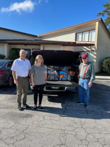 Managing Attorney, Grady H. Williams, Jr., LL.M. is pictured with Executive Assistant and Marketing Manager, Paula Emery and John Rose of Lucas Honda and the 1,100 pounds of food donations for the Food Pantry of Green Cove Springs.