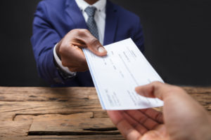 Businessman handing colleague a check