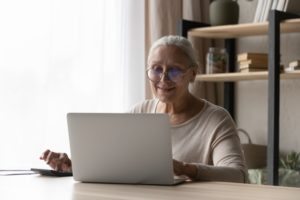 Happy elderly lady using laptop computer 