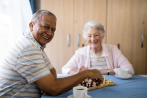 Smiling Senior Man Playing Chess with Friend