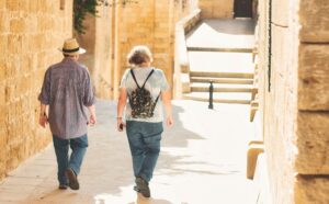 Retired couple living abroad walk through Mediterranean village