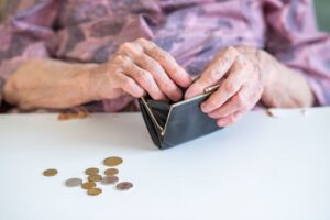 Hands of senior woman looking for change in a coin purse